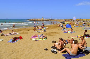 Gouves, Kıbrıs, Yunanistan - 3 Haziran 2019: Girit 'teki Gouves plajında güneşlenen turistler Yunan adalarının en büyük ve en kalabalık adaları.