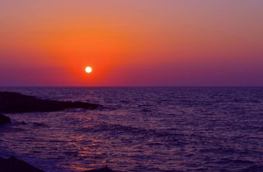 Girit 'te Kato Gouves sahilinde mor ve turuncu gün batımı Akdeniz üzerinde