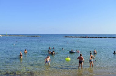 Paphos, Kıbrıs, Yunanistan - 3 Haziran 2018: Paphos sahilinde denizde yüzen turistler Kıbrıs Rum Kesimi 'nde bir tatil beldesi