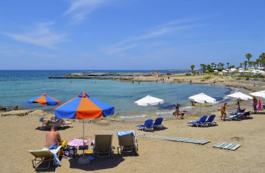 Paphos, Kıbrıs, Yunanistan - 5 Haziran 2018: Paphos plajındaki turistler Kıbrıs 'ta popüler bir turizm beldesi