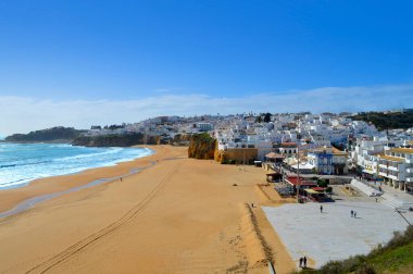 Portekiz 'deki Albufeira Sahili' nde bahar güneşinde yürüyen insanlar 