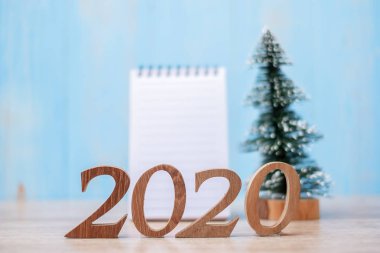 Boş defter ve ahşap numarayla 2020 yılbaşı. Şimdi tam zamanı. 