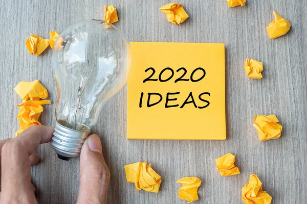 2020 Slova nápadu na žluté notě a drobném papíru s Businessmem — Stock fotografie