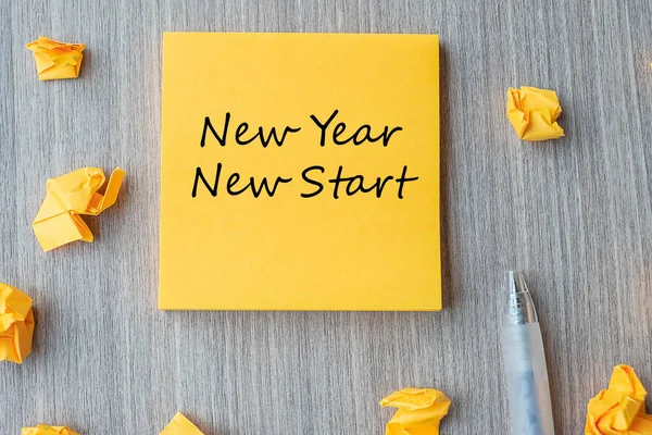 Nytt år Nytt startord på gul lapp med penna och söndersmulad knäpp — Stockfoto