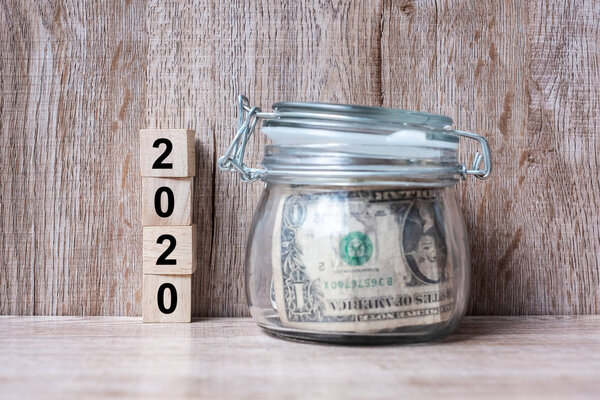 2020 Happy New Year with US dollar money glass American on wood 