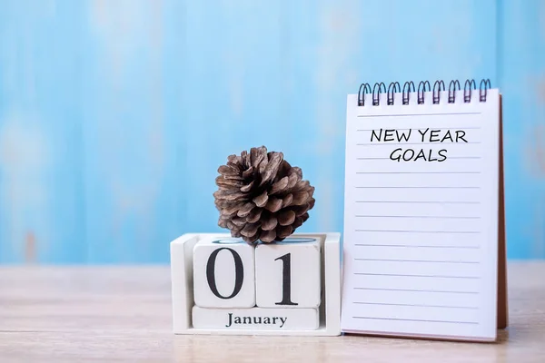 New Year goals word on notebook  and January calendar. time for