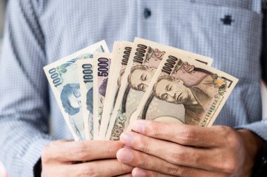 Japon Yen banknot destesini elinde tutan bir iş adamı. iş, 