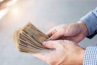 Japon Yen banknot destesini elinde tutan bir iş adamı. iş, 