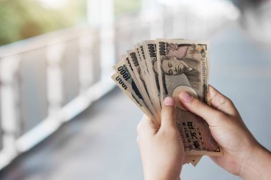 Japon Yen banknot destesini elinde tutan bir iş adamı. iş, 