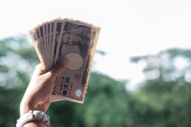 Japon Yen banknot destesini elinde tutan bir iş kadını. iş