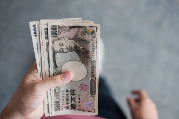 Mão de mulher de negócios segurando pilha de notas de iene japonês. negócios — Fotografia de Stock