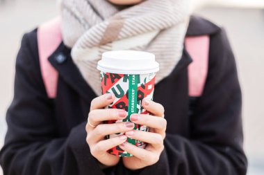Kadın elleri sıcak Starbucks kahve fincanı tutuyor, Noel için.
