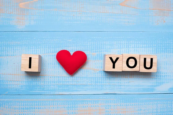 I LOVE YOU wooden cubes with red heart shape decoration on blue table background and copy space for text. Love Romantic and Happy Valentines day holiday concept