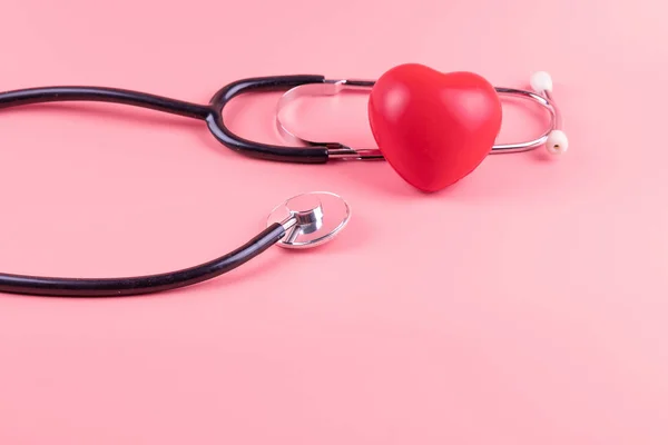 Stethoskop mit roter Herzform auf rosa Hintergrund. Gesundheit, — Stockfoto