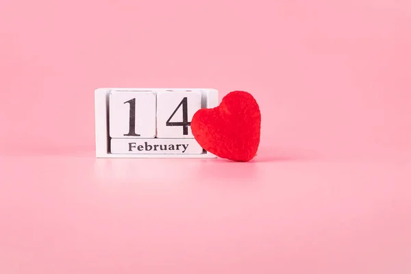 Red heart shape decoration with 14 February calendar on pink bac — Stock Photo, Image