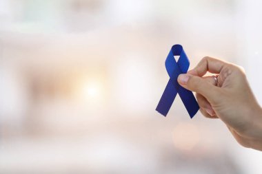 March Colectal Cancer farkındalık ayı, Koyu mavi R tutan adam.