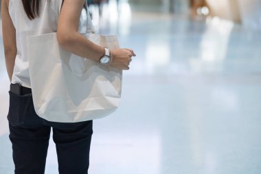 Arka planda Eko-Alışveriş torbasını tutan bir kadın var.