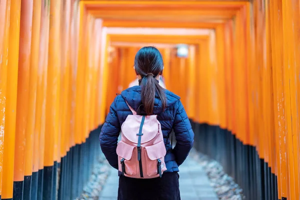 Fushimi Inari Taisha Tapınağında seyahat eden genç bir kadın, mutlu Asya