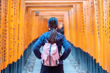 Fushimi Inari Taisha Tapınağında seyahat eden genç bir kadın, mutlu Asya
