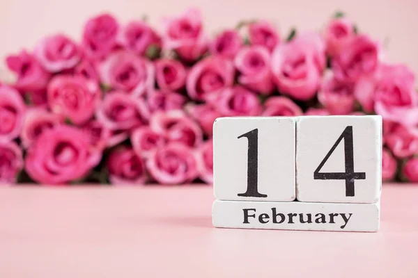 Roze roos bloem en 14 februari Kalender op roze achtergrond. — Stockfoto
