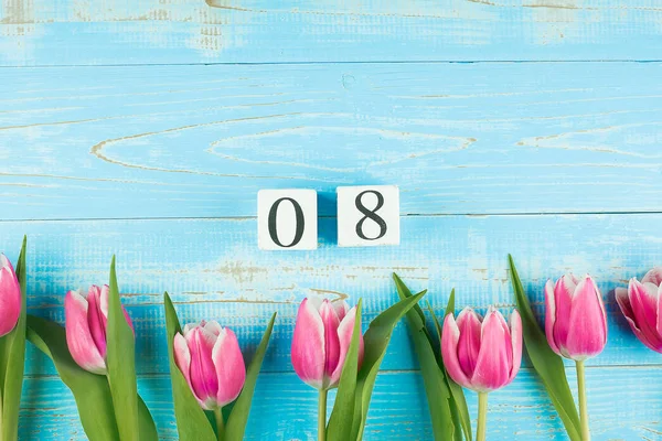 Fleur de tulipe rose et calendrier du 8 mars sur table en bois bleu — Photo