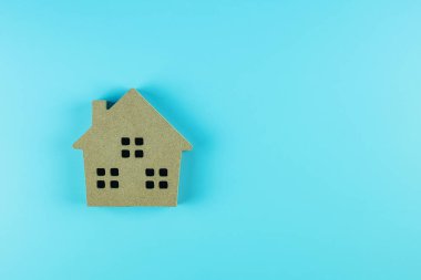 Üstteki ev modeli mavi arkaplanda ve metin için kopya alanı var. Bankacılık, gayrimenkul, yatırım, finans, tasarruf kavramları