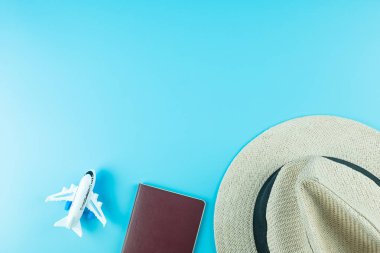 Üst görünüm Şapka, Pasaport ve Uçak modeli mavi arkaplanda metin için kopyalama alanı ile. Seyahat ve Tatil kavramı
