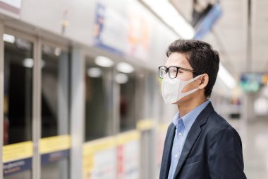 Kamu tren istasyonunda Roman Coronavirüs ya da Corona Virüs Hastalığı 'na (Covid-19) karşı koruyucu maske takan genç Asyalı bir adam solunum yolu enfeksiyonuna yol açan bulaşıcı bir virüstür.