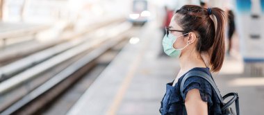 Devlet tren istasyonunda Novel Coronavirus ya da Corona Virüs Hastalığı 'na (Covid-19) karşı cerrahi maske takan genç Asyalı kadın. Hijyen, Sağlık ve Enfeksiyon Konsepti