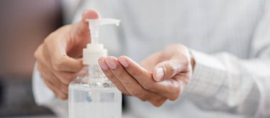 Erkek eli, Novel Coronavirus veya Corona Virüs Hastalığı (Covid-19) için el yıkama jeli veya dezenfektan şişesi kullanmaktadır. Antiseptik, Hijyen ve Sağlık Konsepti