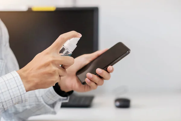 Man Hand Spuiten Alcohol Ontsmettingsmiddel Fles Naar Smartphone Tegen Novel — Stockfoto