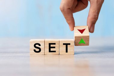 İş adamı Hand, tahta bloğu SET metni (Tayland Borsası) ile UP ve Down ok simgesi ile değiştirdi. Faiz oranı, hisse senetleri, finans, sıralama, ipotek oranları ve kayıp konsepti