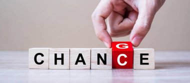 İş adamı masa arkasındaki tahta küpleri bozuk paralarla değiştirip Chance yazısına çeviriyor. Kriz, başarı, strateji, çözüm, iş ve olumlu düşünce kavramları