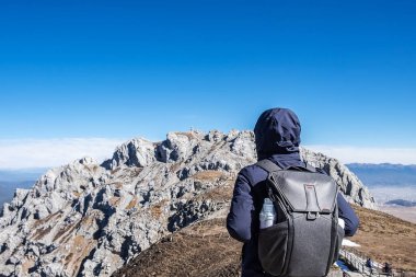 Shika Karlı Dağ veya Mavi Ay Vadisi 'nde seyahat eden genç bir gezgin, Zhongdian (Shangri-La) şehrinde turistlerin uğrak yeridir. Yunnan, Çin. Asya ve Solo seyahat kavramı