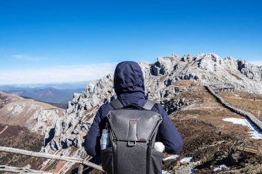 Shika Karlı Dağ veya Mavi Ay Vadisi 'nde seyahat eden genç bir gezgin, Zhongdian (Shangri-La) şehrinde turistlerin uğrak yeridir. Yunnan, Çin. Asya ve Solo seyahat kavramı