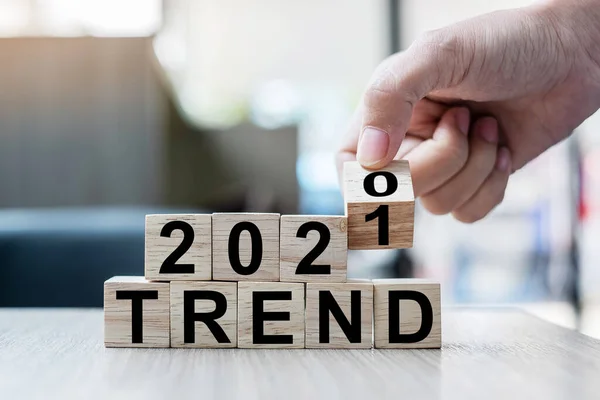 İş adamı elindeki tahta küple 2020 'den 2021' e kadar masa arkasında TRENDS sözcüğü var. Çözüm, strateji, çözüm, hedef, iş ve yeni yıl tatili kavramları