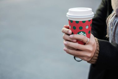 Noel ve yeni yıl koleksiyonu için Starbucks 'ın sıcak kahve fincanlarını tutan kadın elleri. Kunming, Çin, 10 Aralık 2019