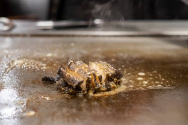 Teppanyaki Japon Şefi restoranda yemek pişirip ızgara yaparken tavada ızgara kabuklu deniz ürünleri ya da deniz ürünleri. Kobe Bölgesi, Hyogo, Japonya 'da turistler için lezzetli ve popülerdir.
