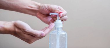 Erkek eli, Novel Coronavirus veya Corona Virüs Hastalığı (Covid-19) için el yıkama jeli veya dezenfektan şişesi kullanmaktadır. Antiseptik, Hijyen ve Sağlık Konsepti
