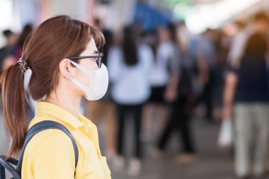 Korunaklı yüz maskesi takan genç Asyalı kadın, devlet tren istasyonunda koronavirüs veya Corona Virüs Hastalığı 'nı (Covid-19) engelliyor. Enfeksiyon ve Salgın Konsepti