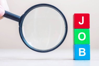 İş metni ahşap küp bloklar ve masa arkasında büyüteç. İşsizlik, insan kaynakları, mülakat ve adam toplama kavramı