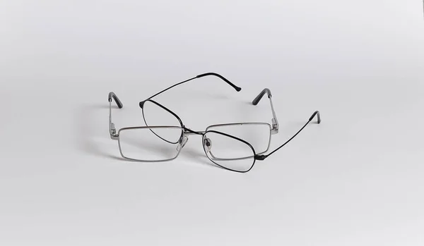眼鏡の2つのペアが彼らの間で戦っている ペアの底は敵の上にあります 白い背景に隔離されたメガネのクローズアップ — ストック写真