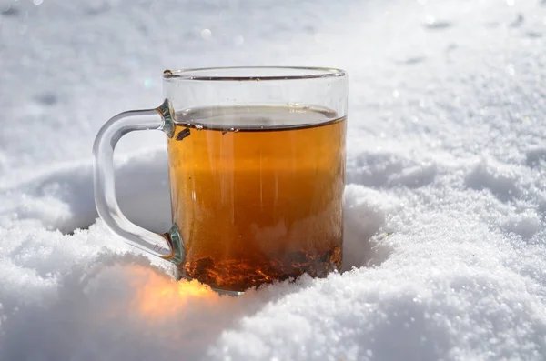 Copa de té de vidrio en la nieve en la mañana invierno estado de ánimo Navidad —  Fotos de Stock