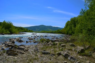 Uçurumlar arasındaki dağ nehri. Nehrin mavi berrak suyu.