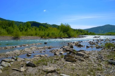 Uçurumlar arasındaki dağ nehri. Nehrin mavi berrak suyu.