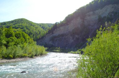 Uçurumlar arasındaki dağ nehri. Nehrin mavi berrak suyu.