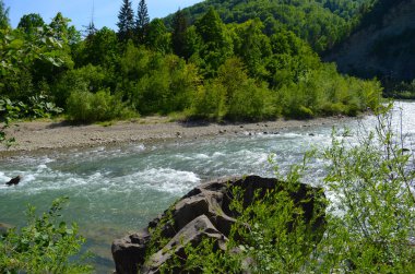 Uçurumlar arasındaki dağ nehri. Nehrin mavi berrak suyu.