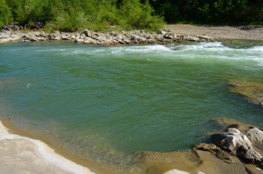 Uçurumlar arasındaki dağ nehri. Nehrin mavi berrak suyu.