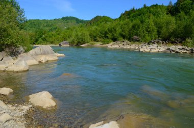 Uçurumlar arasındaki dağ nehri. Nehrin mavi berrak suyu.