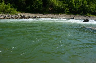 Uçurumlar arasındaki dağ nehri. Nehrin mavi berrak suyu.